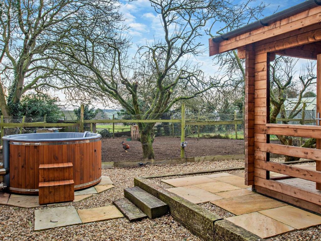 einen Whirlpool in einem Garten neben einem Holzgebäude in der Unterkunft 2 Bed in Kibworth Harcourt 94141 in Market Harborough