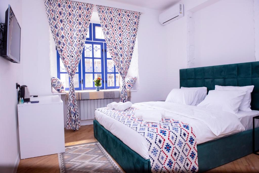 a bedroom with a large bed and two windows at Pallada in Yerevan