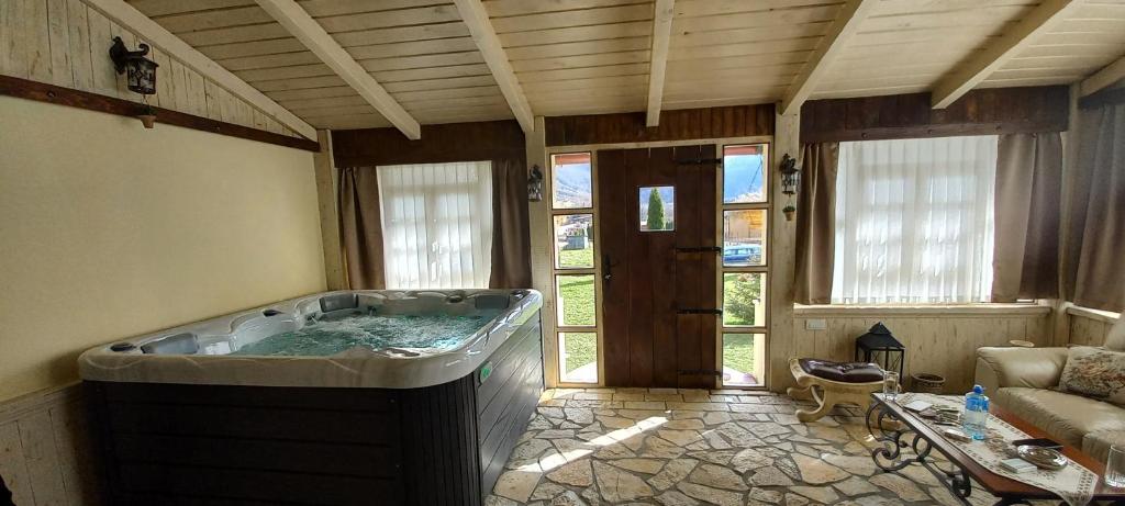 uma grande banheira num quarto com um sofá em Vila Merak em Gusinje