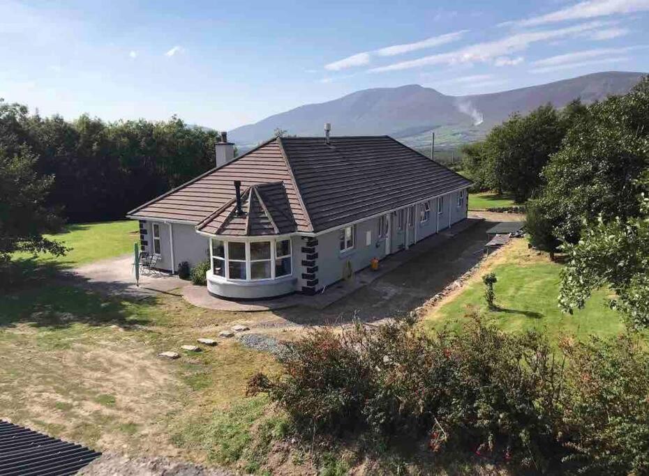 uma vista aérea de uma casa com montanhas ao fundo em The Marshes - Large home, short drive to beach em Kells