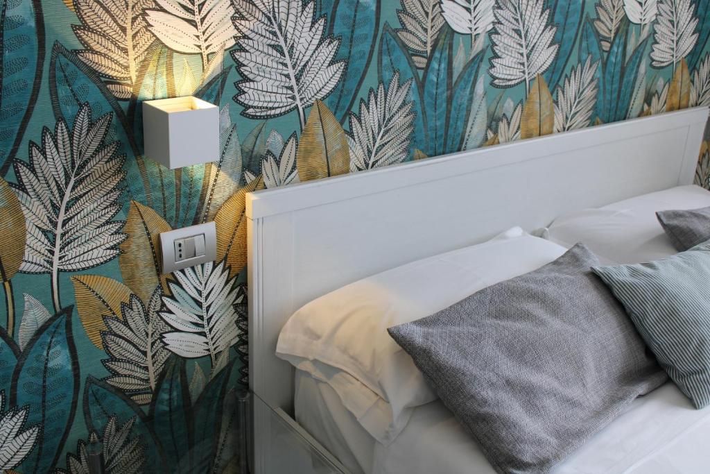 a bedroom with a green and white leaf wallpaper at De Gasperi 55 in Naples