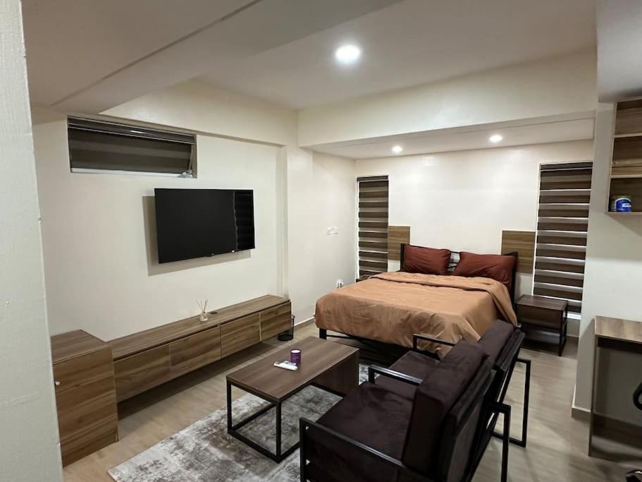a bedroom with a bed and a flat screen tv at Pelumi’s Studio in Lagos