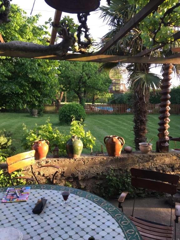 une table dans un jardin avec des vases dessus dans l'établissement Mas dans son écrin de verdure, à Orange