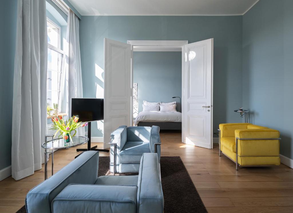 een blauwe woonkamer met een bank en een bed bij The New Yorker BOARDINGHOUSE in Keulen