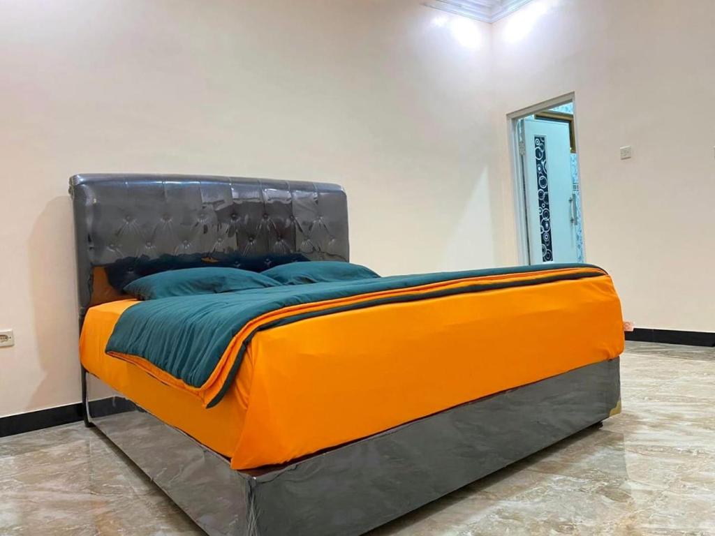 Ce lit se trouve dans un dortoir doté d'oreillers orange et bleu. dans l'établissement Villa la famile, à Cisarua