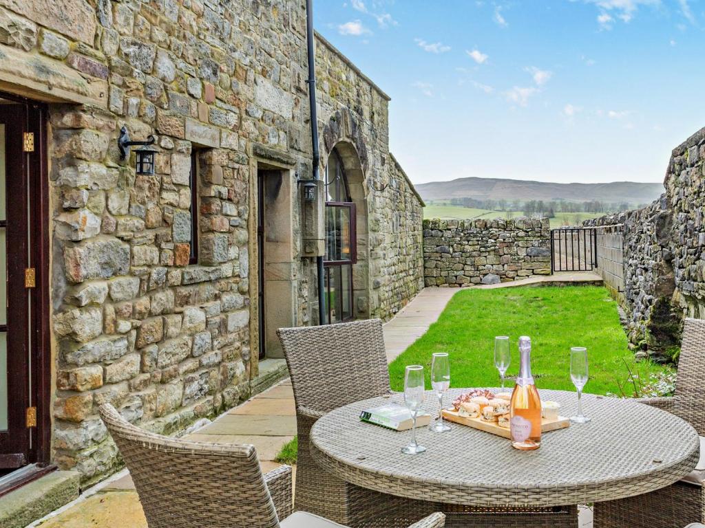 a patio with a table and chairs and a stone building at 2 Bed in Malham 94261 in Airton
