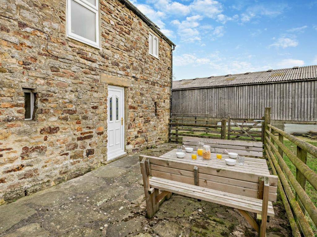 a wooden bench sitting in front of a brick building at 2 Bed in Wolsingham 94197 in Wolsingham