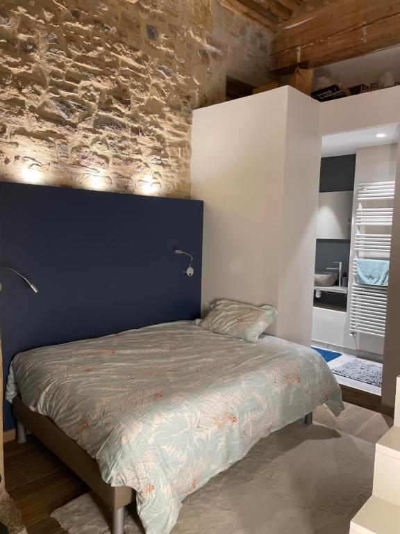 a bedroom with a bed with a brick wall at Chambre B&B dans appartement vue Saône calme absolu in Lyon