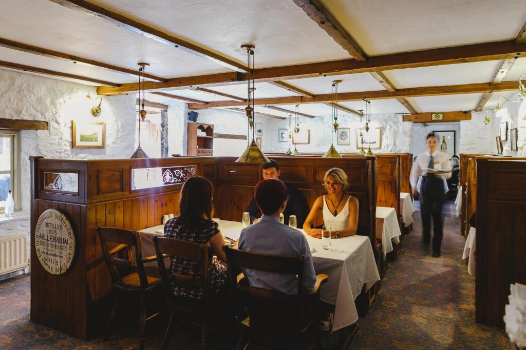 a group of people sitting at tables in a restaurant at Bushmills Inn Hotel & Restaurant in Bushmills