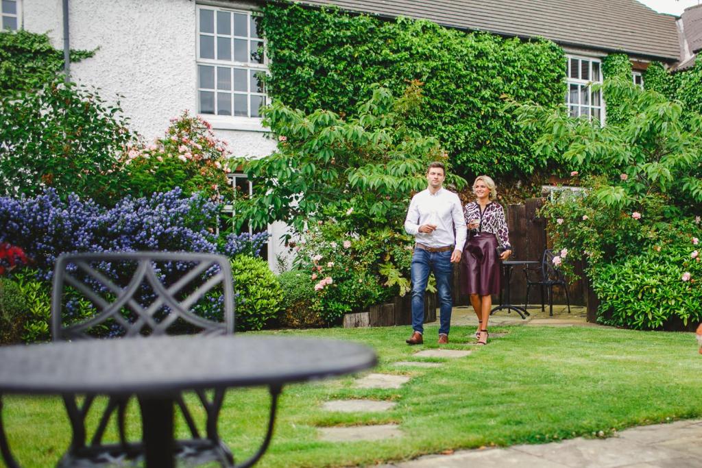 a man and a woman walking through a yard at Bushmills Inn Hotel & Restaurant in Bushmills