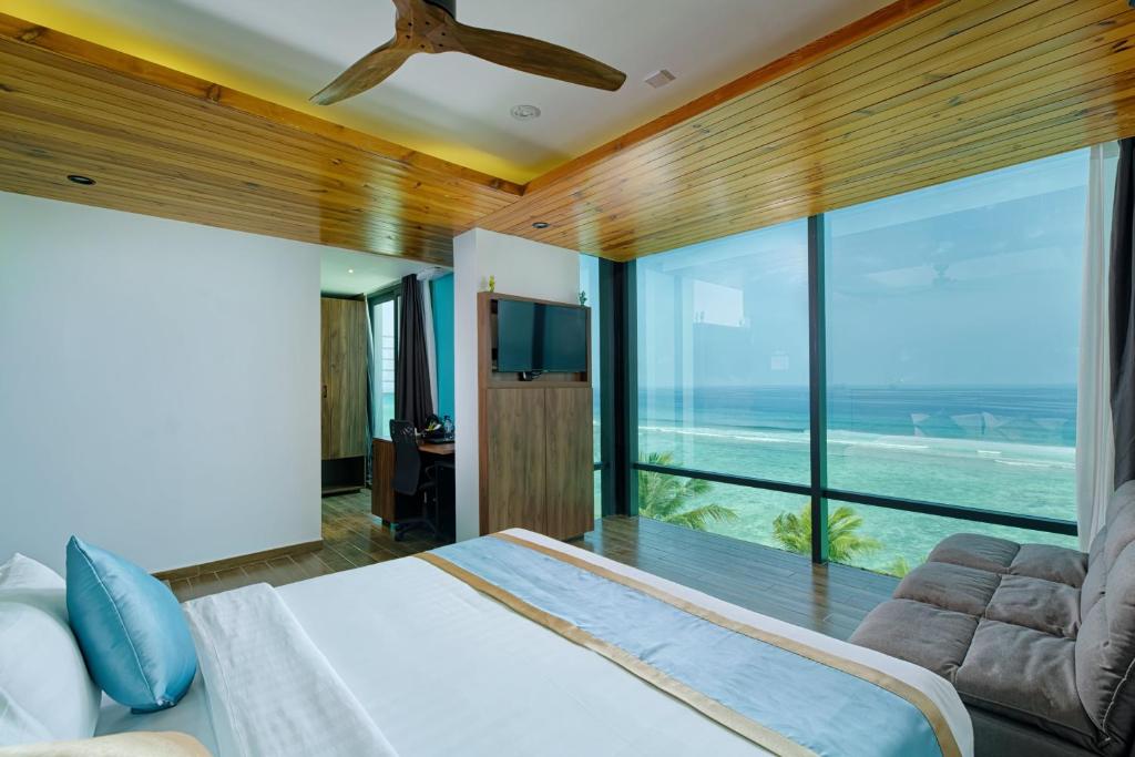 ein Schlafzimmer mit einem Bett und einem großen Fenster in der Unterkunft h78 veli in Hulhumale