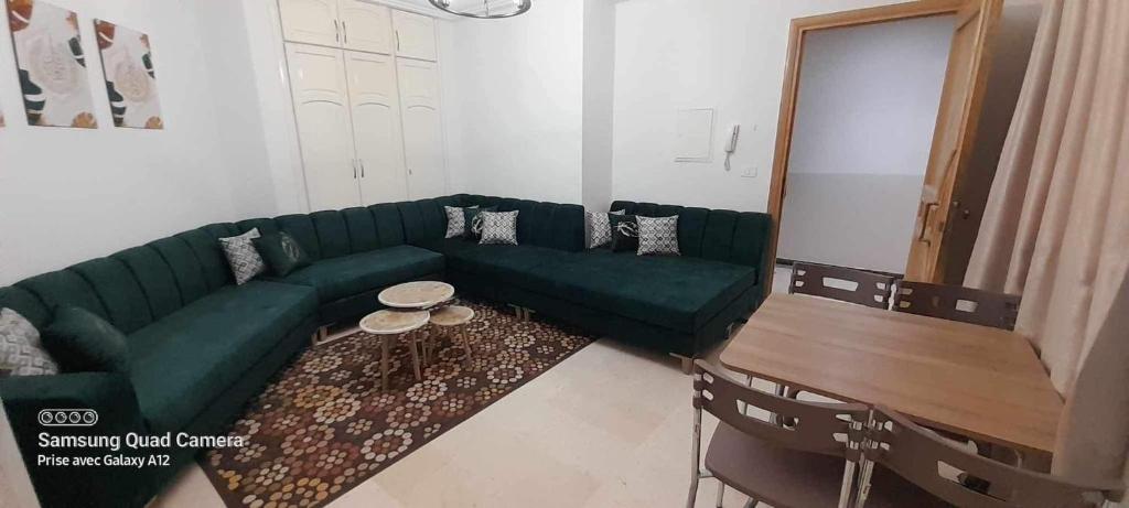 sala de estar con sofá verde y mesa en عمارة سيتي سنتر صفاقس en Sfax