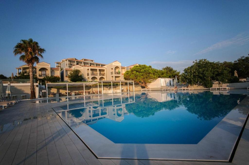 a large pool of water in front of a building at The Bay Hotel & Suites in Vasilikos