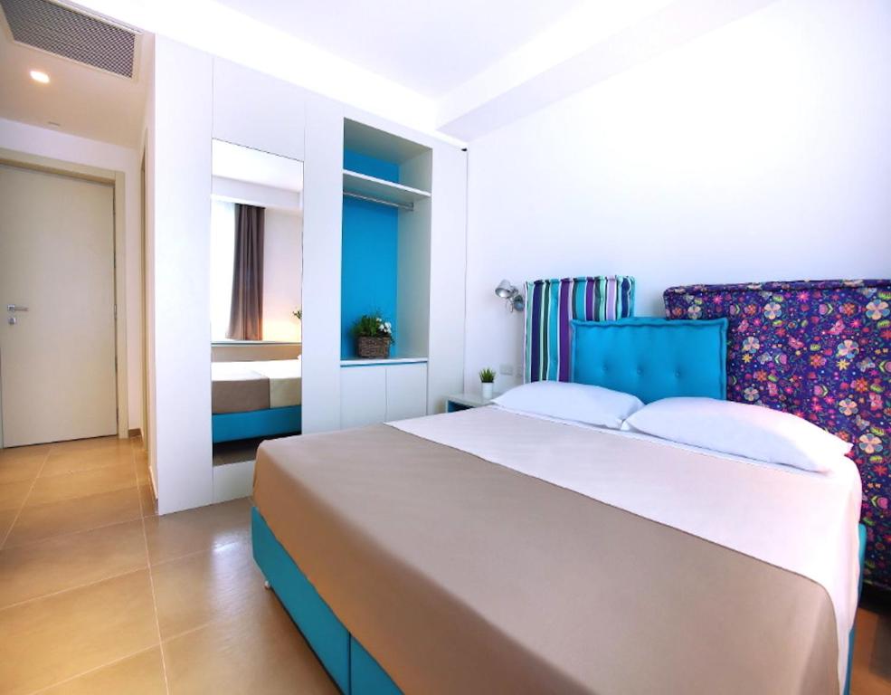 a bedroom with a large bed and a chair at Hotel Cicò in Torre Santa Sabina