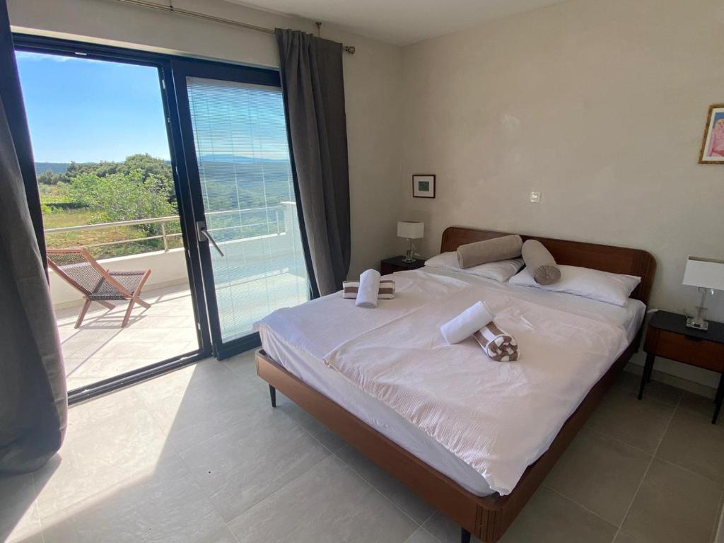 1 dormitorio con 1 cama y vistas a un balcón en Luxury Villa "SREĆA" en Rab
