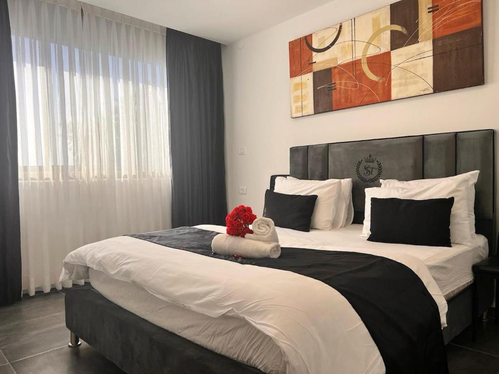 Un dormitorio con una cama grande con un animal de peluche. en Elis Boutique Hotel, en Bat Yam