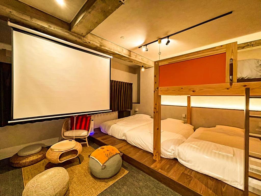 a bedroom with two beds and a large screen at Many Thanks Resort Onomichi - Vacation STAY 15792 in Onomichi