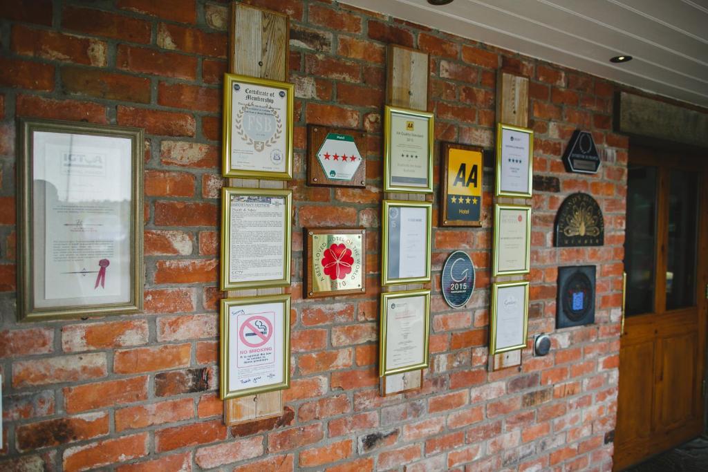 a brick wall with framed signs on it at Bushmills Inn Hotel & Restaurant in Bushmills