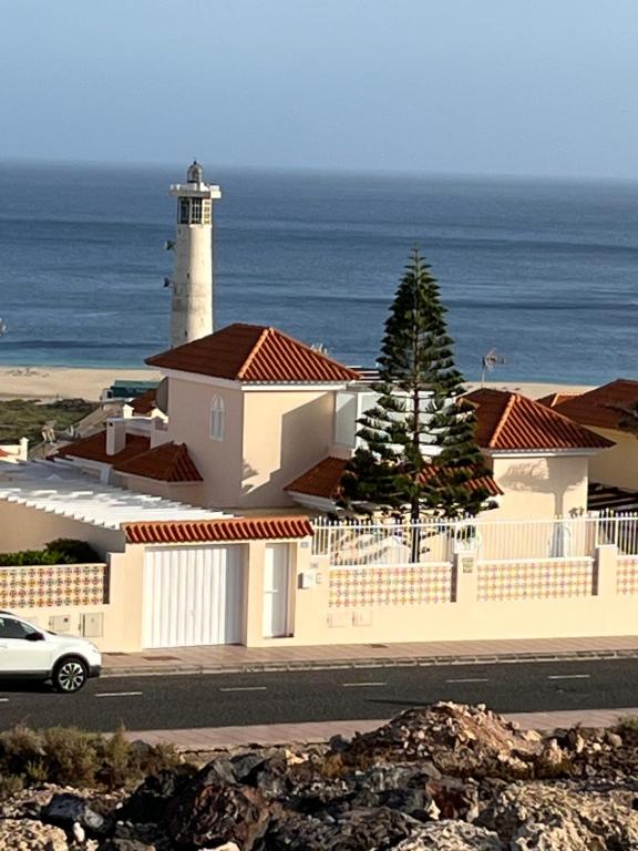 a lighthouse on the side of a road next to the ocean at Vista del Mar 2 in Morro del Jable