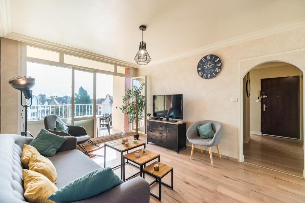 a living room with a couch and a tv at L’Escapade Bretonne - Appt à 10min de la plage in Saint-Brieuc