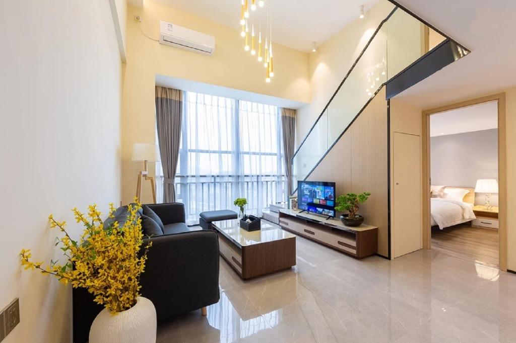 a living room with a couch and a television at Serveyou International Apartment - Free Airport Pickup Service & Free Pazhou Complex Shuttle Bus & Free Sanyuan Li Xiaobei Baiyun Wholesale Market shuttle bus in Guangzhou