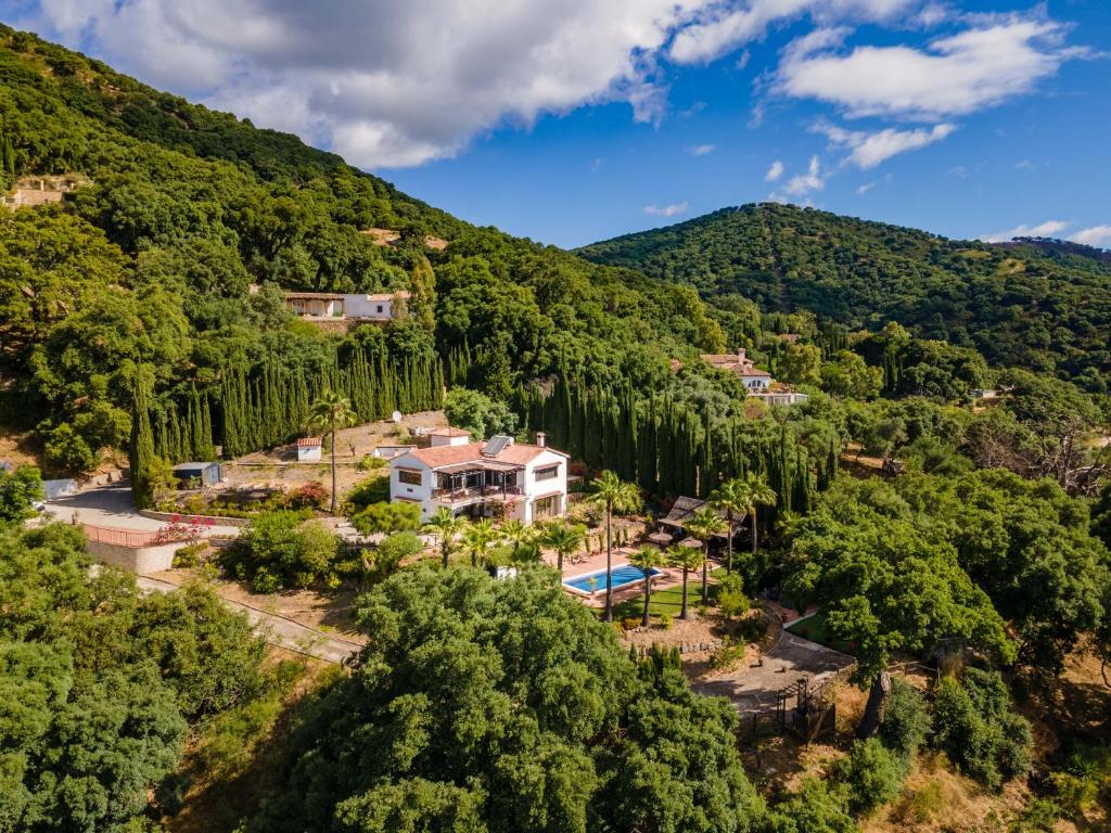 eine Luftansicht eines Hauses in den Hügeln mit Bäumen in der Unterkunft Luxury country house with pool and breathtaking views in Casares