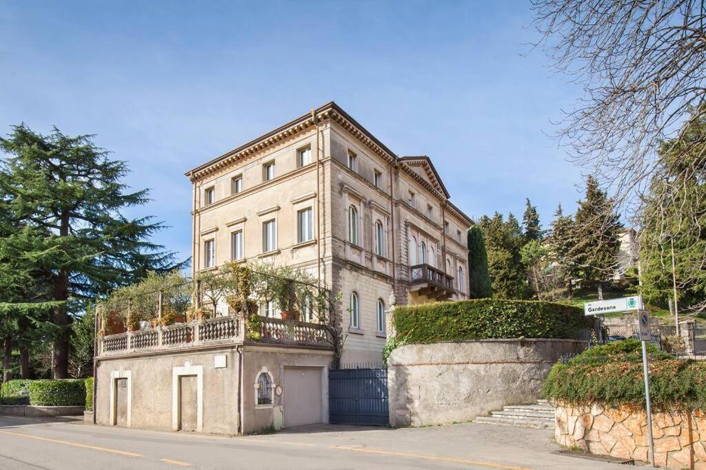 een groot stenen gebouw met een balkon aan een straat bij Villa Lidia-Dimora storica a Caprino Veronese in Caprino Veronese