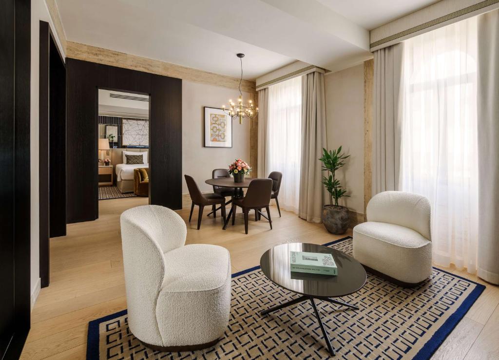 بارك حياة ميلانو في ميلانو: غرفة معيشة مع كراسي بيضاء وطاولة