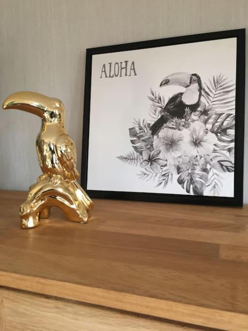 un robinet en or et une photo sur une table dans l'établissement L’appart Quessoy, à Quessoy