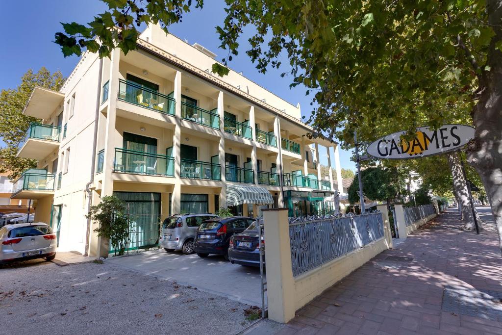 un edificio con coches estacionados frente a él en Hotel Gadames - Lunch on the Beach, en Cervia
