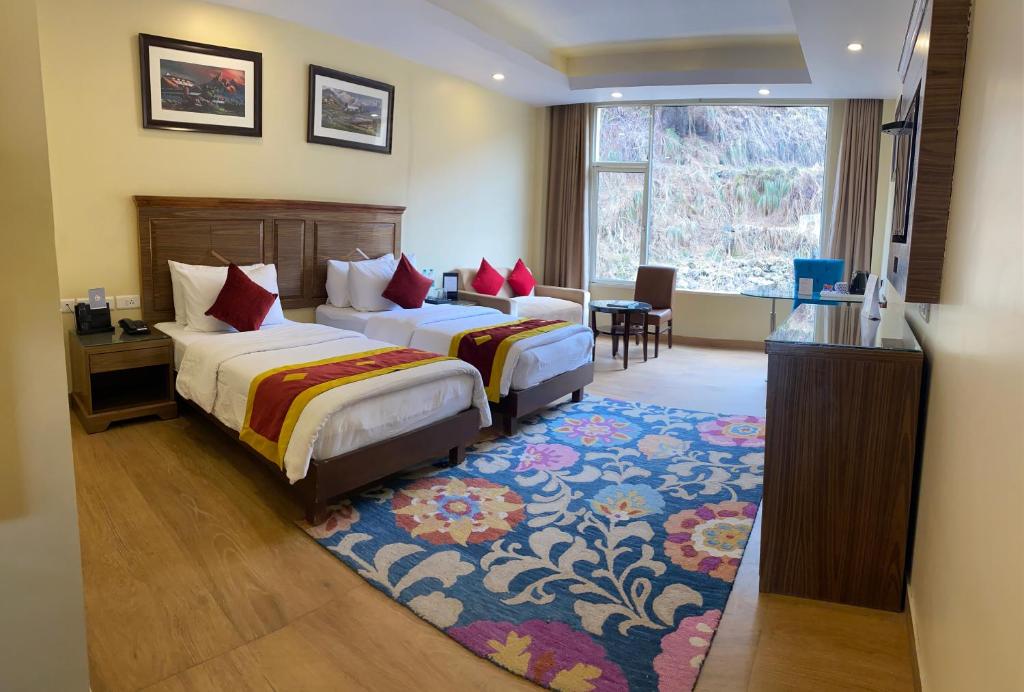 a hotel room with two beds and a window at Fortune Park Kufri, Shimla - Member ITC's Hotel Group in Shimla