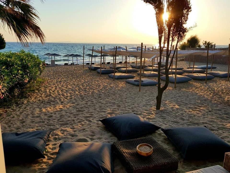 a row of pillows on a beach with the ocean at The Bay Hotel & Suites in Vasilikos