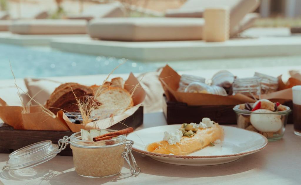 a table with a plate of food and a box of food at The Bay Hotel & Suites in Vasilikos