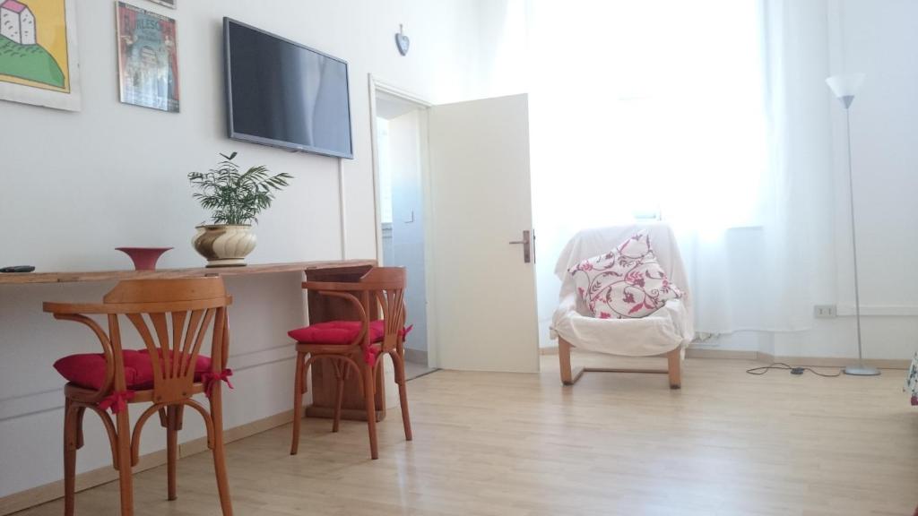 a living room with a desk and chairs and a tv at B&B Fratelli in Senigallia