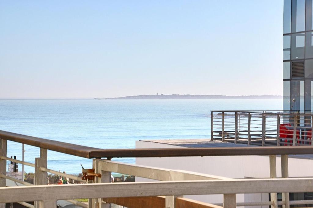 a view of the ocean from the balcony of a building at Eden On The Bay 118 by HostAgents in Bloubergstrand