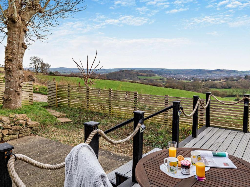 a wooden deck with a table with drinks on it at 1 Bed in Bridport 94154 in Chideock