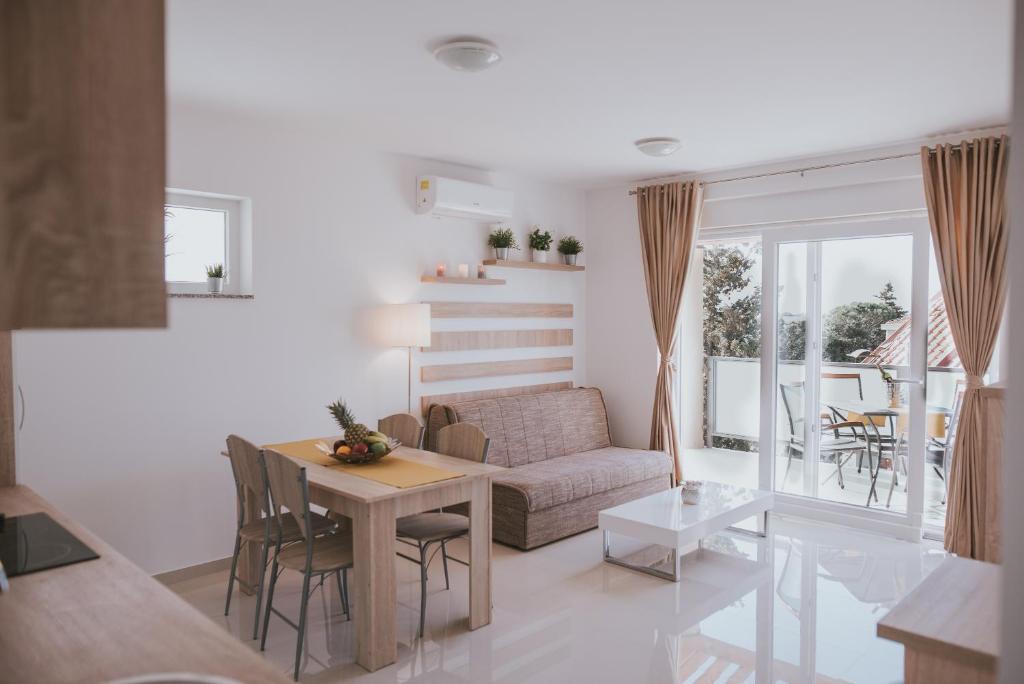 a living room with a table and a couch at Poolside Hideout Apartments in Novalja