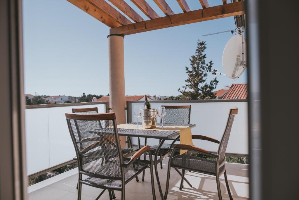 a table and chairs on a balcony with a view at Poolside Hideout Apartments in Novalja