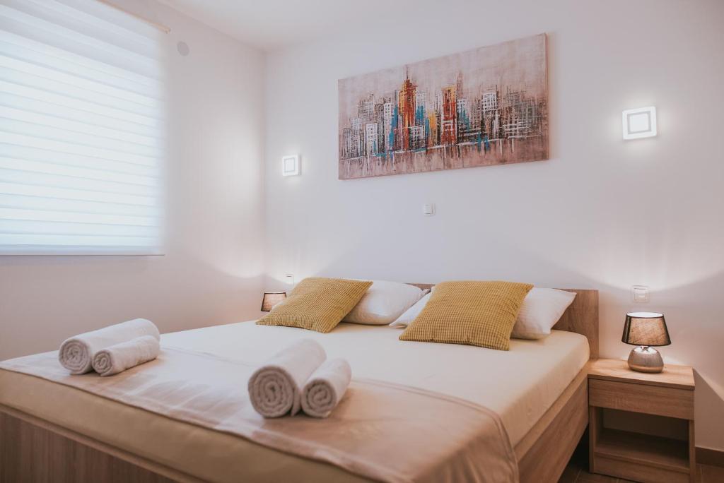 a bedroom with a bed with towels on it at Poolside Hideout Apartments in Novalja