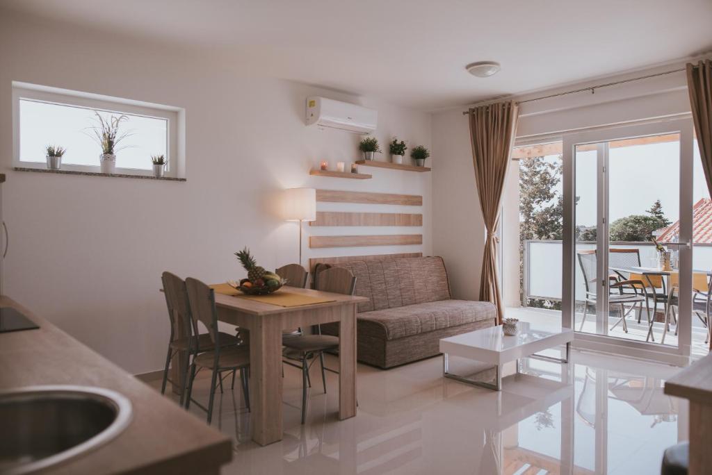 a living room with a table and a couch at Poolside Hideout Apartments in Novalja