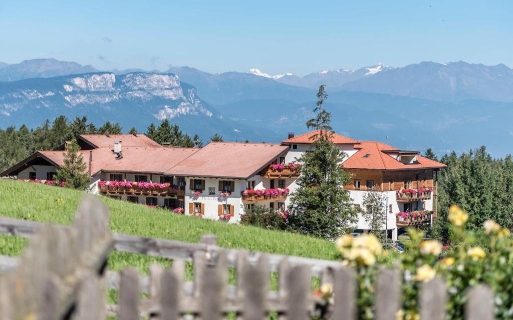 a building on a hill with mountains in the background at Hotel Peter in Petersberg