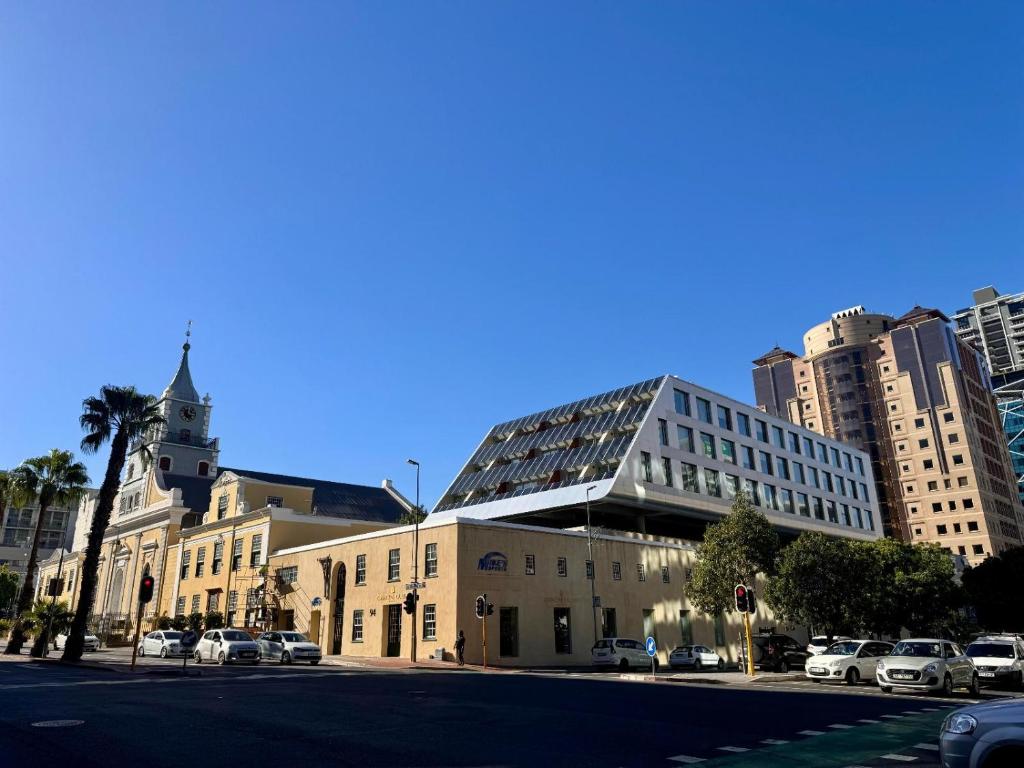 a large building with a clock tower on a city street at Bree Street Apartment - Explore, Eat, Experience Cape Town in Cape Town