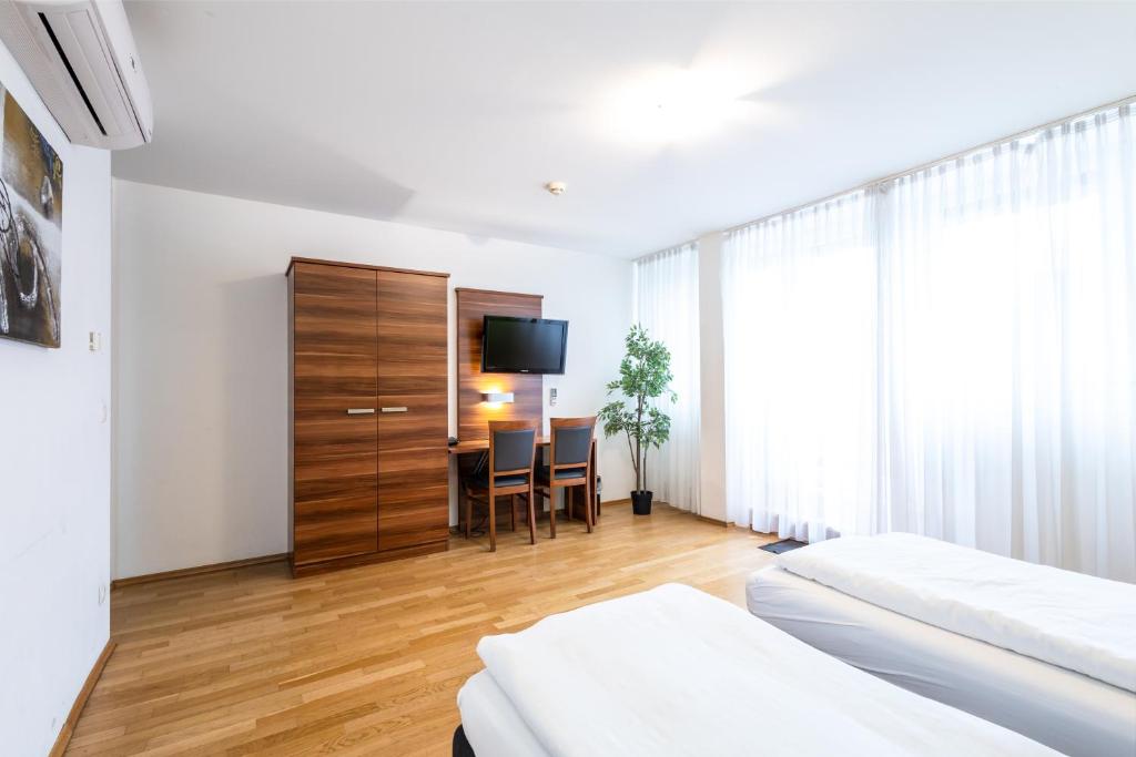ein Hotelzimmer mit einem Schlafzimmer mit einem Tisch und einem Fernseher in der Unterkunft Sky Apartments Vienna in Wien