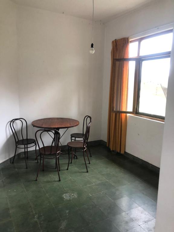 a table and chairs in a room with a window at Poneloya in Tarija