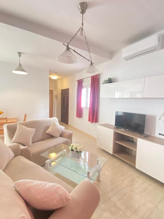 a living room with a couch and a tv at Casa Encina in Torremolinos