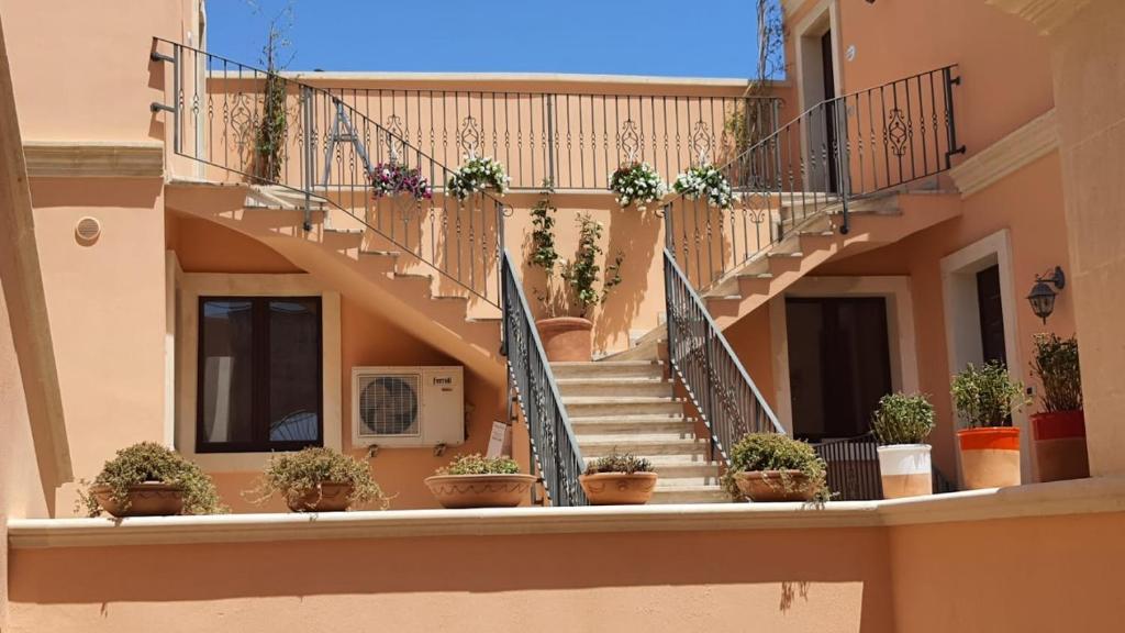 uma escada num edifício com vasos de plantas em Corte dei Fiori Acquaviva Apartments em Marittima