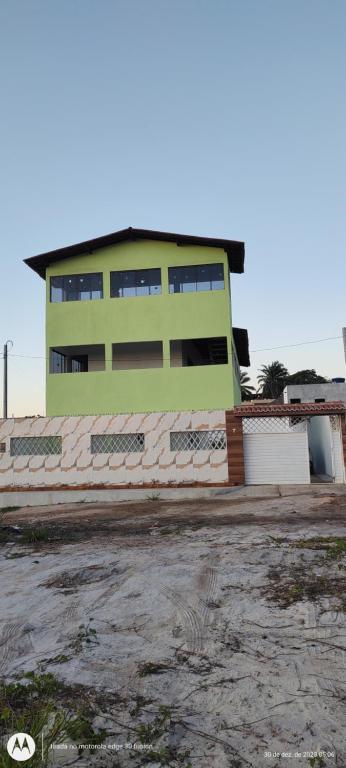 um edifício verde em frente a um parque de estacionamento em não disponível! em Itamaracá