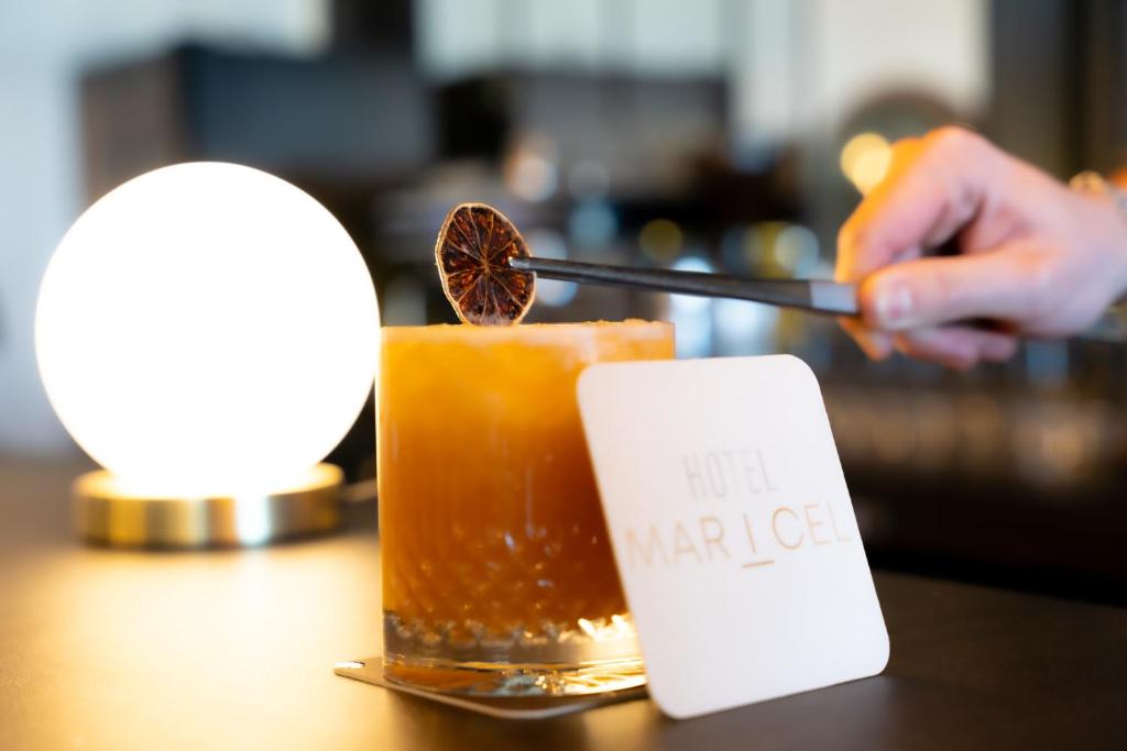 a person is preparing a drink on a table at Hôtel Mar I Cel &amp; Spa in Canet-en-Roussillon