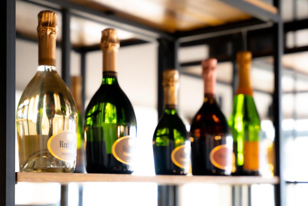 a row of wine bottles on a shelf at Hôtel Mar I Cel &amp; Spa in Canet-en-Roussillon