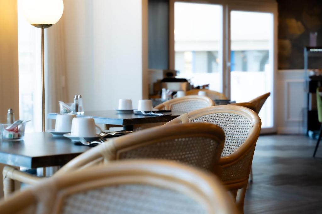 a row of tables and chairs in a restaurant at Hôtel Mar I Cel &amp; Spa in Canet-en-Roussillon